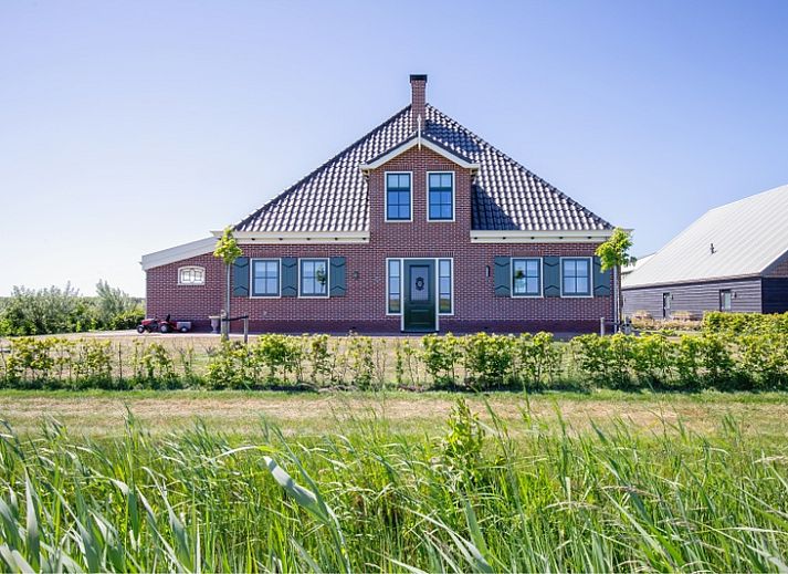 Stijlvolle eetruimte in Appartement C, De Cocksdorp, Texel met houten tafel en moderne keuken.