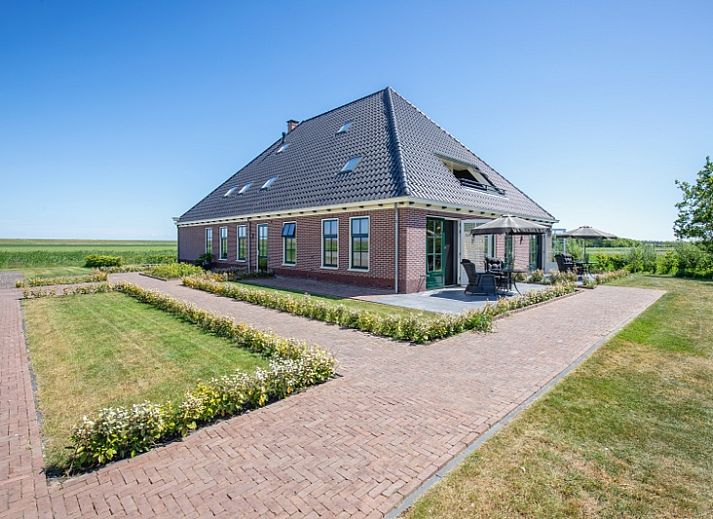 Stijlvolle eetruimte in Appartement C, De Cocksdorp, Texel met houten tafel en moderne keuken.
