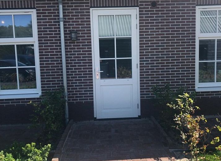 Stijlvolle eetruimte in Appartement C, De Cocksdorp, Texel met houten tafel en moderne keuken.