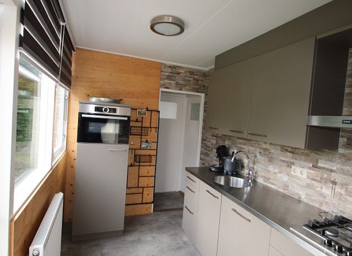 Gemuetliches Wohnzimmer im Bungalow Tamarisk 164 - Bartje, De Cocksdorp, Texel mit bequemem Sofa und viel Tageslicht.