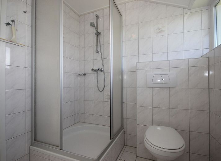 Gezellige woonkamer in Bungalow De Witte Hoek 6 Pers., De Cocksdorp, Texel met comfortabel interieur en tuinzicht.