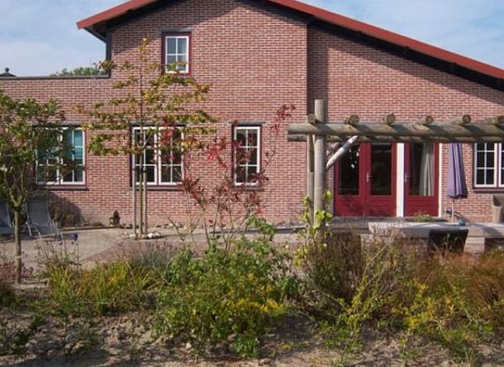Charmante bakstenen gevel van Huisje in De Cocksdorp, Texel, met ruim terras voor ontspanning.