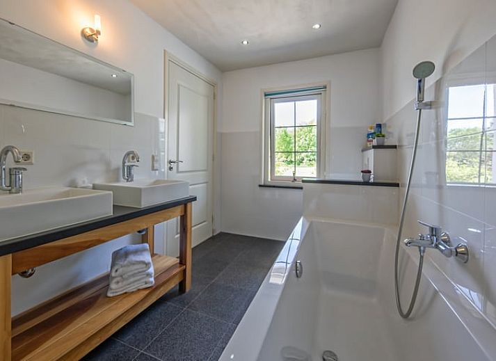 Ruime buitenruimte van vakantiehuis Huisje in De Cocksdorp, Texel, met groene omgeving.