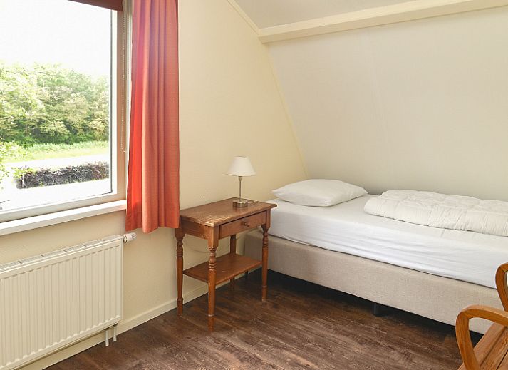 Cozy living room in Vuurtorenwachter, De Cocksdorp, Texel with comfortable furniture and garden views.
