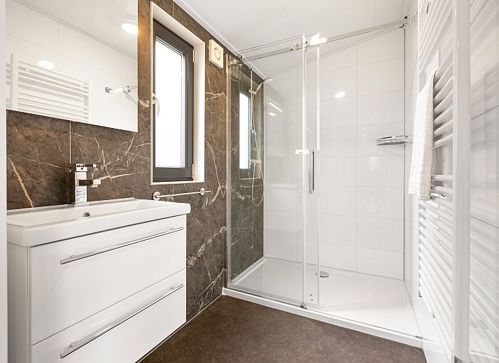 Gemuetliches Wohnzimmer im 6-Personen-Mobilheim Sluftervallei, De Cocksdorp, Texel, mit Blick auf den Garten.