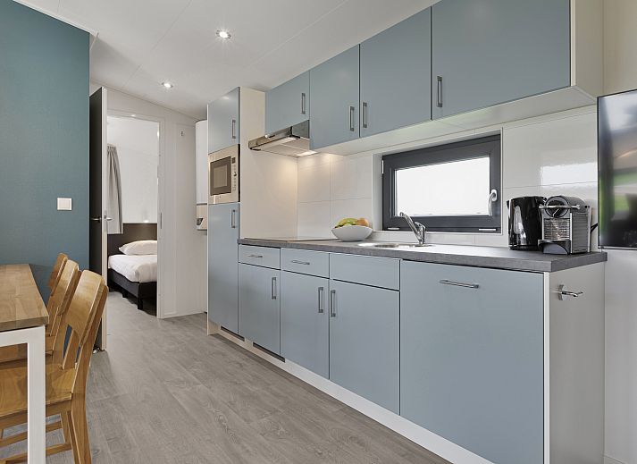 Gemuetliches Wohnzimmer im 6-Personen-Mobilheim Sluftervallei, De Cocksdorp, Texel, mit Blick auf den Garten.