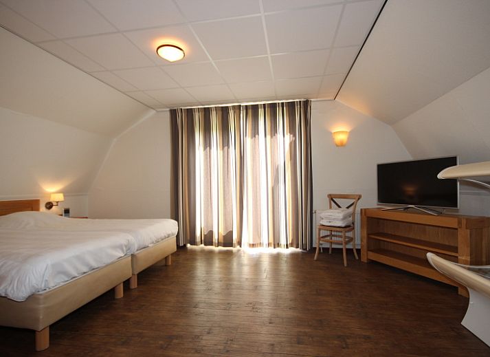 Gemuetliches Wohnzimmer der Villa De Witte Hoek, Ferienhaus in De Cocksdorp, Texel, mit bequemer Sitzecke und gemuetlichem Kamin.