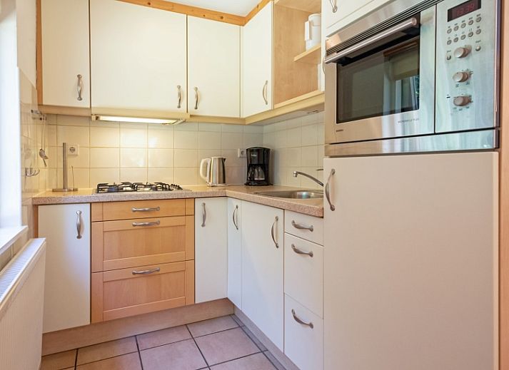 Cozy living room of Holiday home Slufterduin 088, Texel, with comfortable seating and views of the garden.