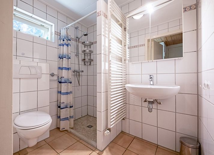 Cozy living room of Holiday home Slufterduin 088, Texel, with comfortable seating and views of the garden.