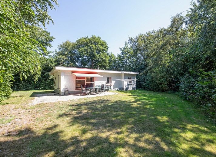 Interior space of Holiday Home Slufterduin 088 in De Cocksdorp, Texel, with red sofa and dining area.