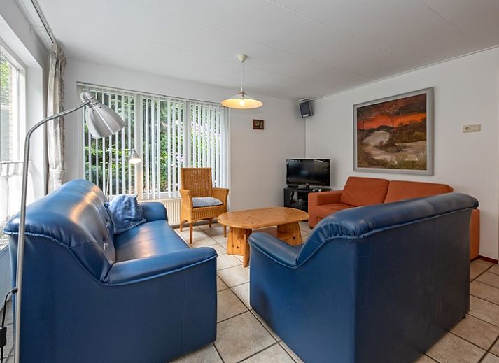 Aussenansicht des Ferienhauses Slufterduin 098 in De Cocksdorp, Texel, mit grosser Terrasse und gruener Umgebung.