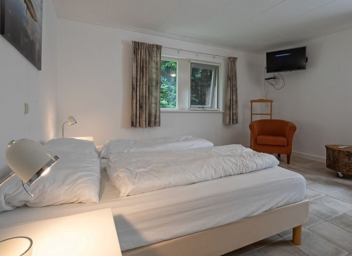 Gemuetliches Wohnzimmer des Ferienhauses Slufterduin 098 in De Cocksdorp, Texel, mit bequemen Sofas und viel Licht.