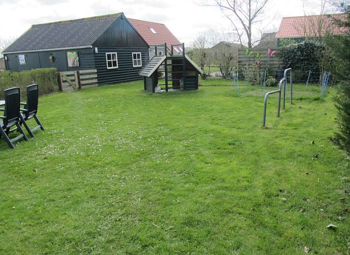 Ruime tuin bij vakantiehuis De Vlinder in De Cocksdorp, Texel, ideaal voor ontspanning en buitenactiviteiten.
