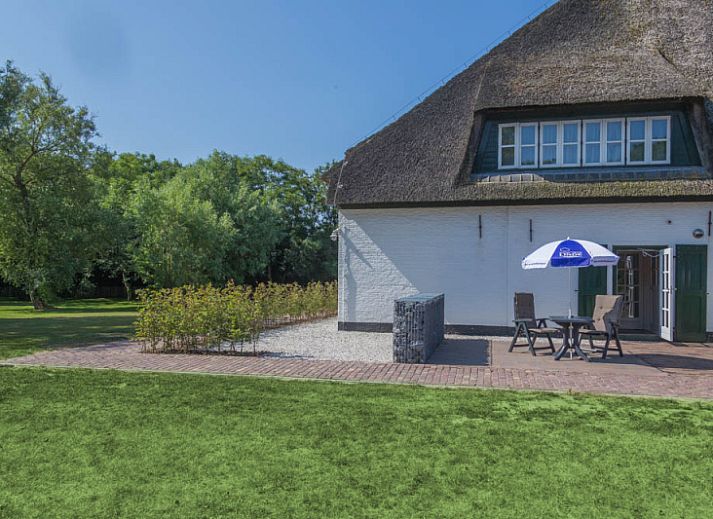 Gemuetliches Wohnzimmer im Ferienhaus Typ R, De Cocksdorp, Texel, mit Sitzecke und Gartenblick.
