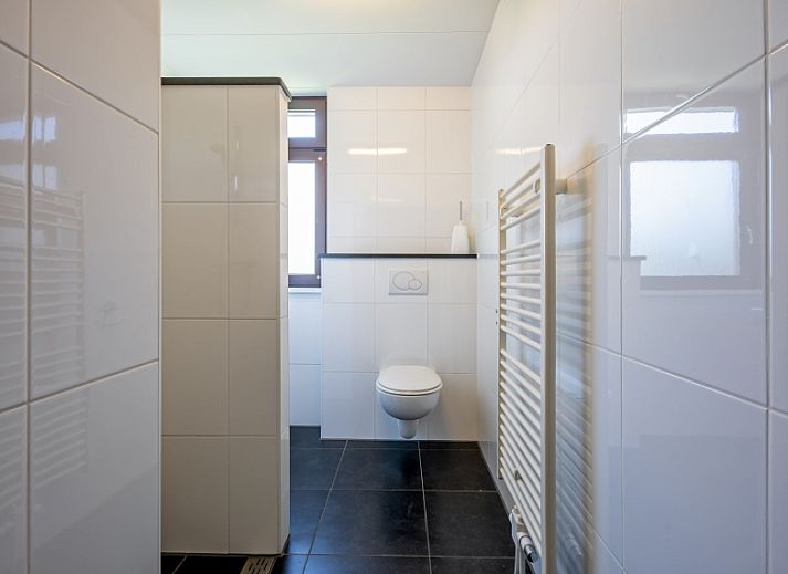 Gemuetliches Wohnzimmer des Ferienhauses Slufterhoek 078, Texel, mit bequemen Sofas und viel Licht.