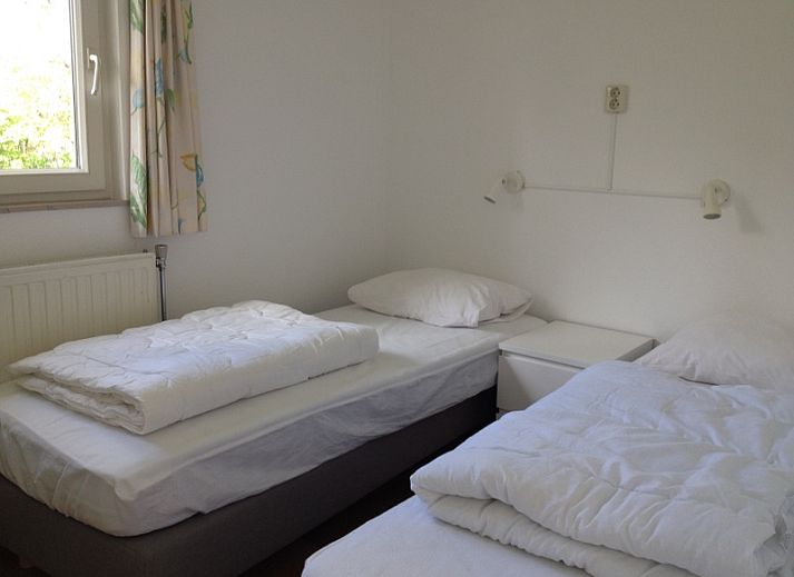 Gemuetliche Sitzecke im Bungalowpark Slufteroord, De Cocksdorp Texel, mit bequemem Sofa und Blick auf den gruenen Garten.