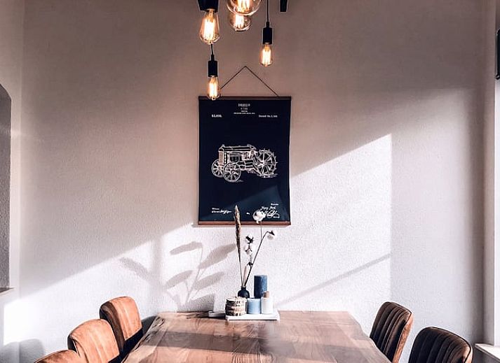 Hinterer Garten und Terrasse des Ferienhauses in De Cocksdorp, Texel, mit grossen Rasenflaechen.