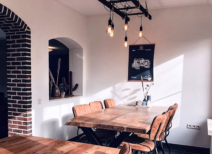 Hinterer Garten und Terrasse des Ferienhauses in De Cocksdorp, Texel, mit grossen Rasenflaechen.