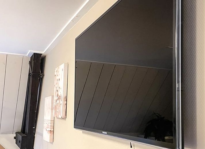 Moderne Kueche im Ferienhaus in De Cocksdorp, Texel, mit grauen Schraenken und kompletten Geraeten.