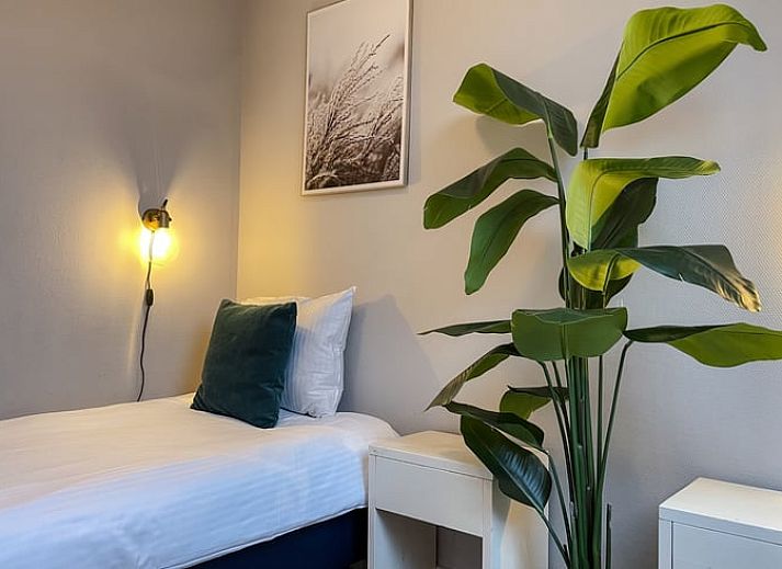 Moderne Kueche im Ferienhaus in De Cocksdorp, Texel, mit grauen Schraenken und kompletten Geraeten.