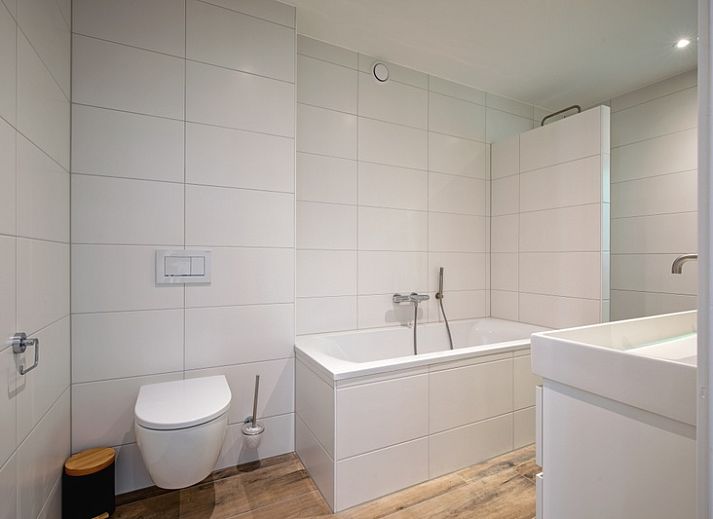 Gezellige woonkamer in Vakantiehuis Slufterhoek 104, De Cocksdorp Texel, met comfortabele zitruimte en sfeervolle inrichting.