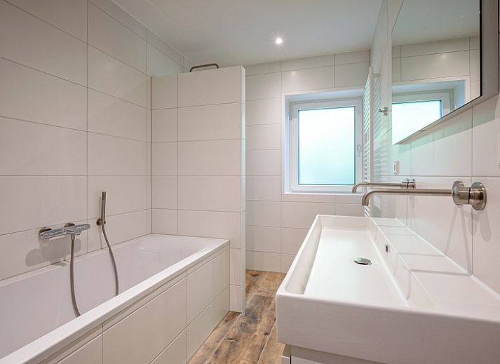 Gezellige woonkamer in Vakantiehuis Slufterhoek 104, De Cocksdorp Texel, met comfortabele zitruimte en sfeervolle inrichting.