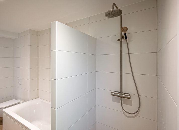 Gezellige woonkamer in Vakantiehuis Slufterhoek 104, De Cocksdorp Texel, met comfortabele zitruimte en sfeervolle inrichting.