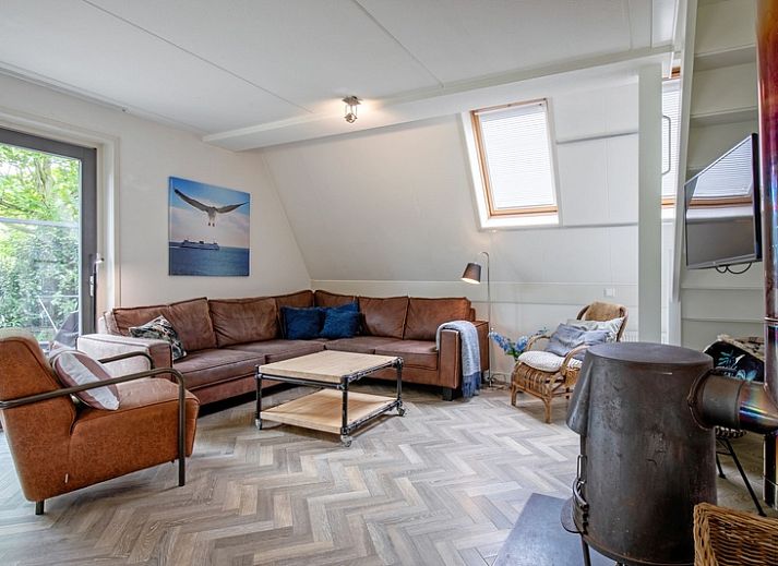 Gezellige eetruimte in Blommetjes Buiten vakantiehuis, De Cocksdorp Texel, met houten tafel en uitzicht op terras.