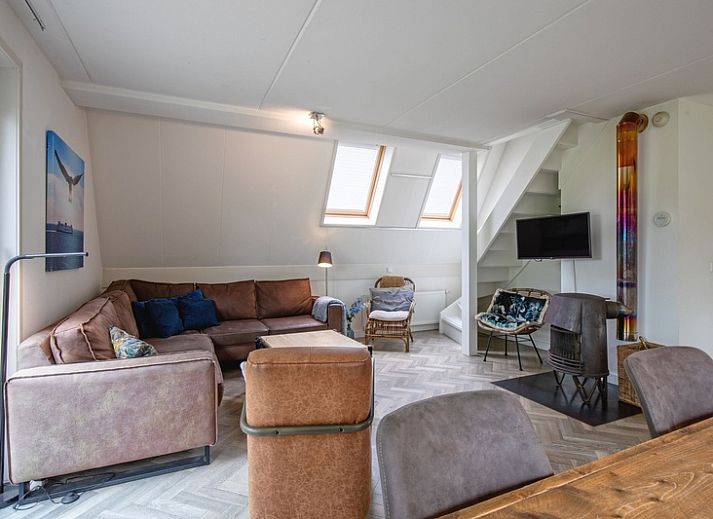 Gezellige eetruimte in Blommetjes Buiten vakantiehuis, De Cocksdorp Texel, met houten tafel en uitzicht op terras.