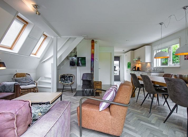 Gezellige eetruimte in Blommetjes Buiten vakantiehuis, De Cocksdorp Texel, met houten tafel en uitzicht op terras.