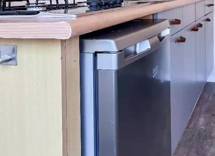 Sfeervolle slaapkamer in Huisje in De Cocksdorp, Texel, met houten lambrisering en zachte verlichting.