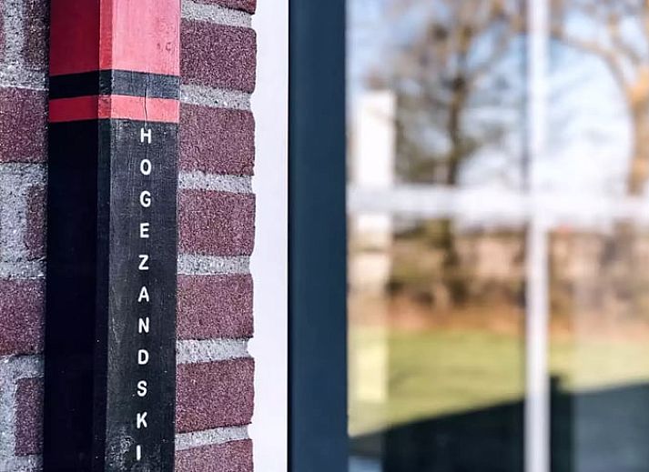 Sfeervolle slaapkamer in Huisje in De Cocksdorp, Texel, met houten lambrisering en zachte verlichting.