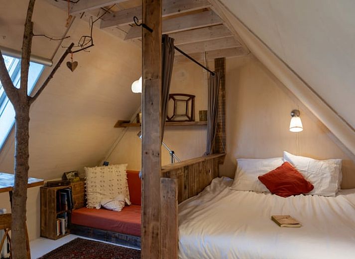Gemuetliches Schlafzimmer im Ferienhaus in De Cocksdorp, Texel, mit Holzinterieur und bequemen Betten.