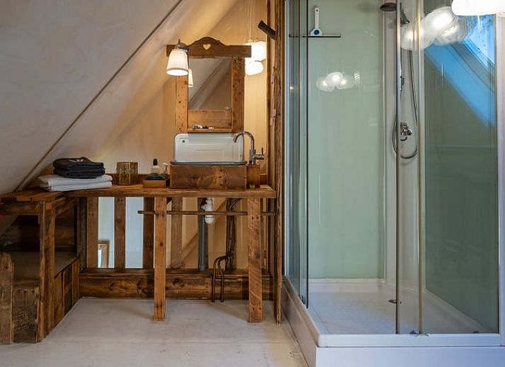 Gemuetliches Schlafzimmer im Ferienhaus in De Cocksdorp, Texel, mit Holzinterieur und bequemen Betten.