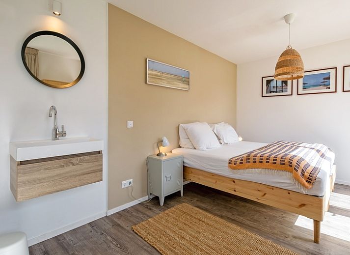 Helles Wohnzimmer im Ferienhaus Slufteroord 292 mit Blick auf den Garten in De Cocksdorp, Texel.