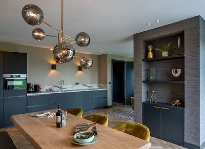 Abendansicht des 6-Personen-Ferienhauses in De Cocksdorp, Texel, mit stimmungsvoller Aussenbeleuchtung.