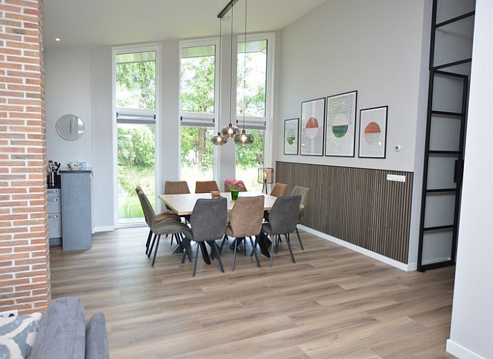 Bright living room of Orchismient 49 vacation home in De Koog, Texel with views of greenery and spacious seating area.