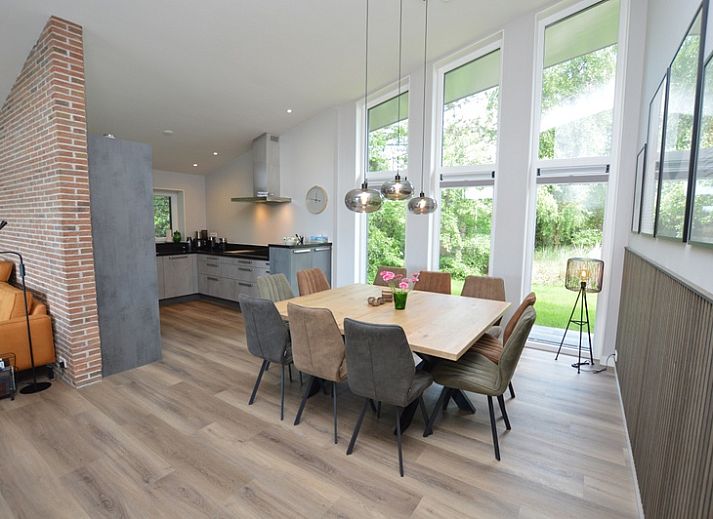 Bright living room of Orchismient 49 vacation home in De Koog, Texel with views of greenery and spacious seating area.