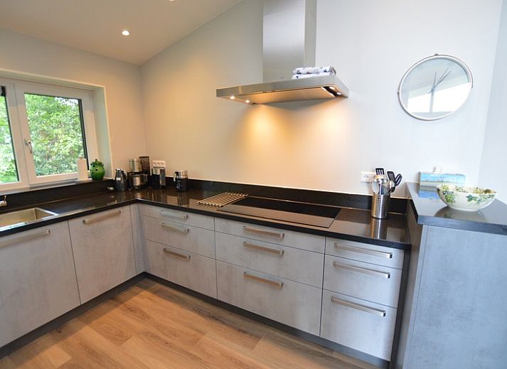 Bright living room of Orchismient 49 vacation home in De Koog, Texel with views of greenery and spacious seating area.