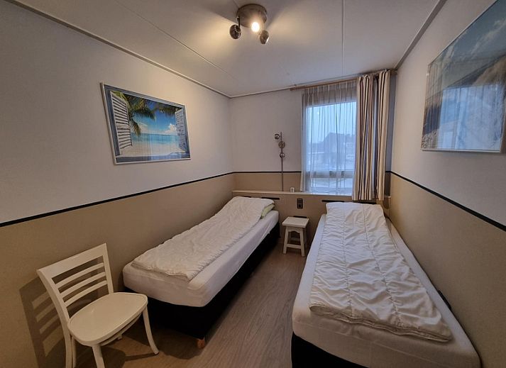 Entrance to Apartments Anna - Zeenevel - 9 in De Koog, Texel, with flowering trees and parking lot.