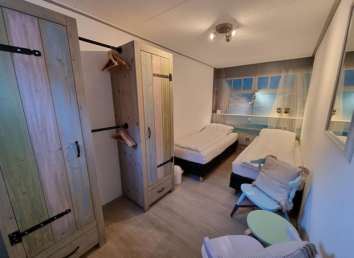 Entrance to Apartments Anna - Zeenevel - 9 in De Koog, Texel, with flowering trees and parking lot.