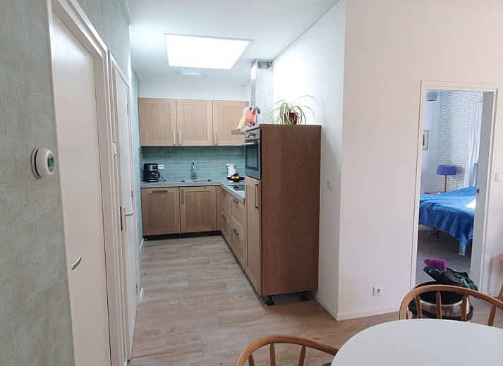 Cozy living room in Huisje Quirijn, De Koog Texel with colorful curtains and French doors to the garden.