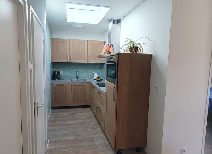 Cozy living room in Huisje Quirijn, De Koog Texel with colorful curtains and French doors to the garden.