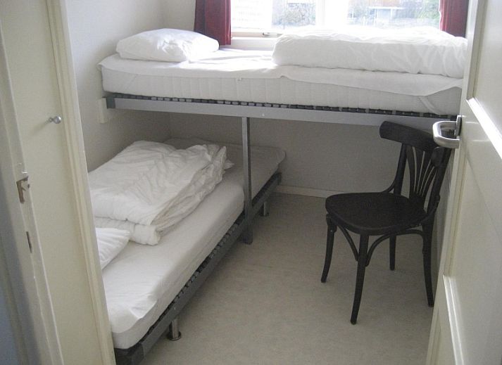 Cozy garden of The Duinputter in De Koog Texel with rocking chair and colorful chairs.