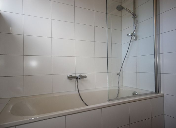 Interior space of Landhuis Landleven No. 81, vacation home in De Koog, Texel with spacious sitting area and wood stove.