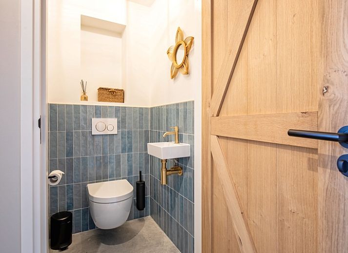 Bright living room of Villa Flo, Texel with large windows and views of the garden.
