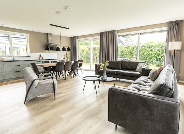 Villa 17 in De Koog, Texel offers a spacious terrace with modern garden furniture and green surroundings for a relaxing vacation.