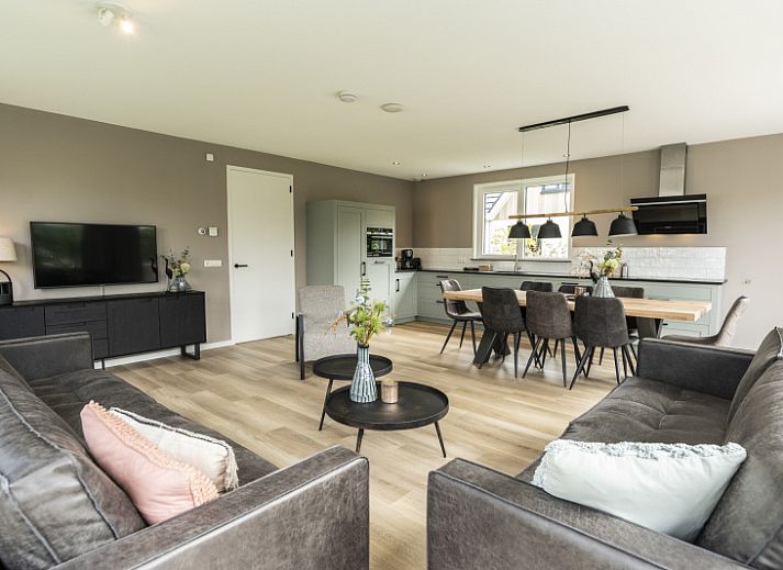 Villa 17 in De Koog, Texel offers a spacious terrace with modern garden furniture and green surroundings for a relaxing vacation.