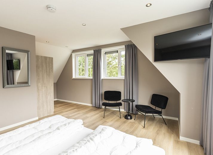 Stylish living room of Villa 17 in De Koog, Texel with open kitchen and garden view for a comfortable stay.