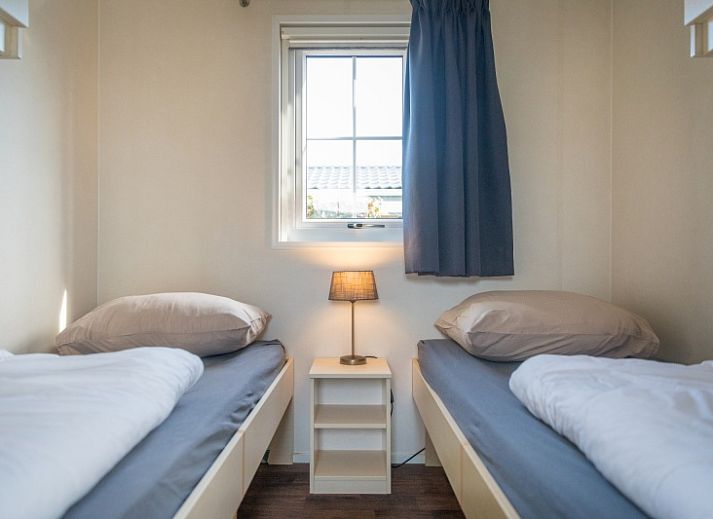 Cozy living room in Chalet Bregkoog 227, Chaletpark Bregkoog, De Koog, Texel with comfortable sofa and colorful armchair.